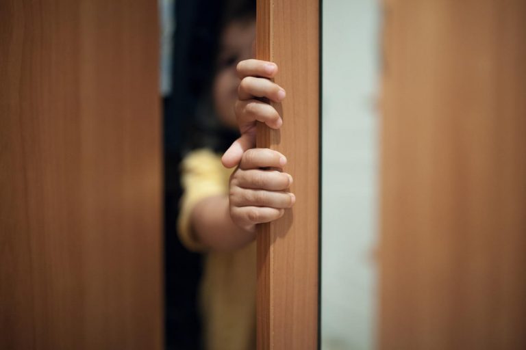 little kid playing hide and seek game;