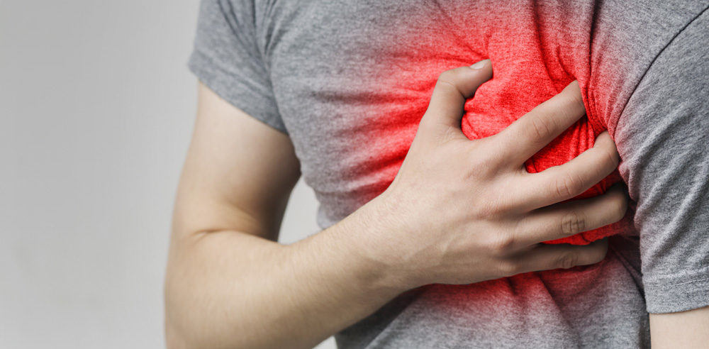 Heart attack or stroke. Caucasian man having heart ache, holding hand on chest, close up